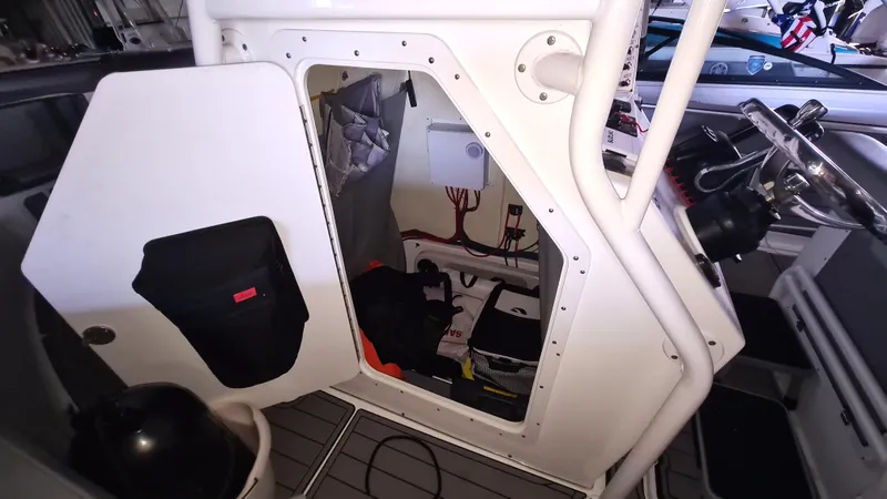 Slide: The Image of 2021 Clearwater 2800 CC boat interior with open storage compartment and visible wiring. - 11