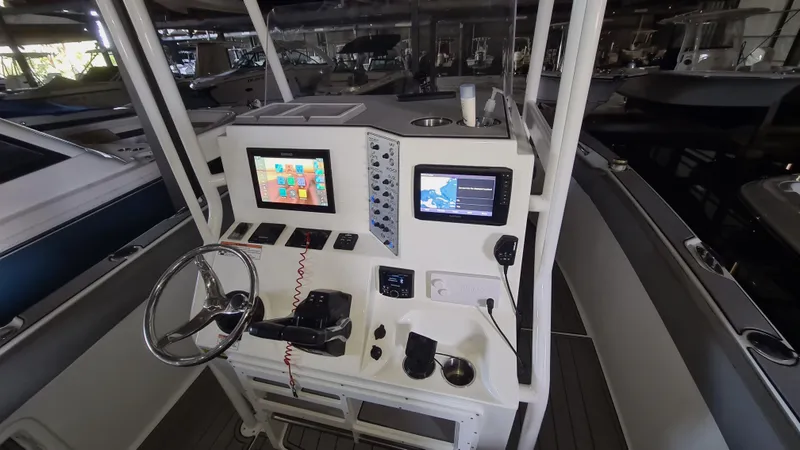 Slide: The Image of 2021 Clearwater 2800 CC boat console with steering wheel and navigation screens. - 13