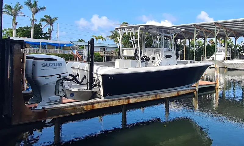 Slide: The Image of 2021 Clearwater 2800 CC boat with Suzuki outboard motor docked in marina. - 2