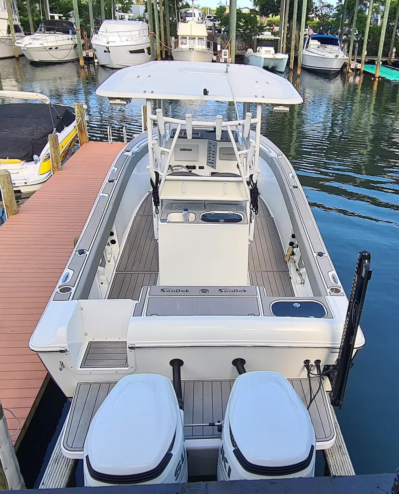 Slide: The Image of 2021 Clearwater 2800 CC boat docked in a marina with multiple vessels. - 3