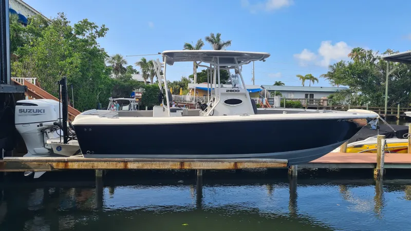 The Image of 2021 Clearwater 2800 CC boat docked, featuring a Suzuki outboard motor. - 0