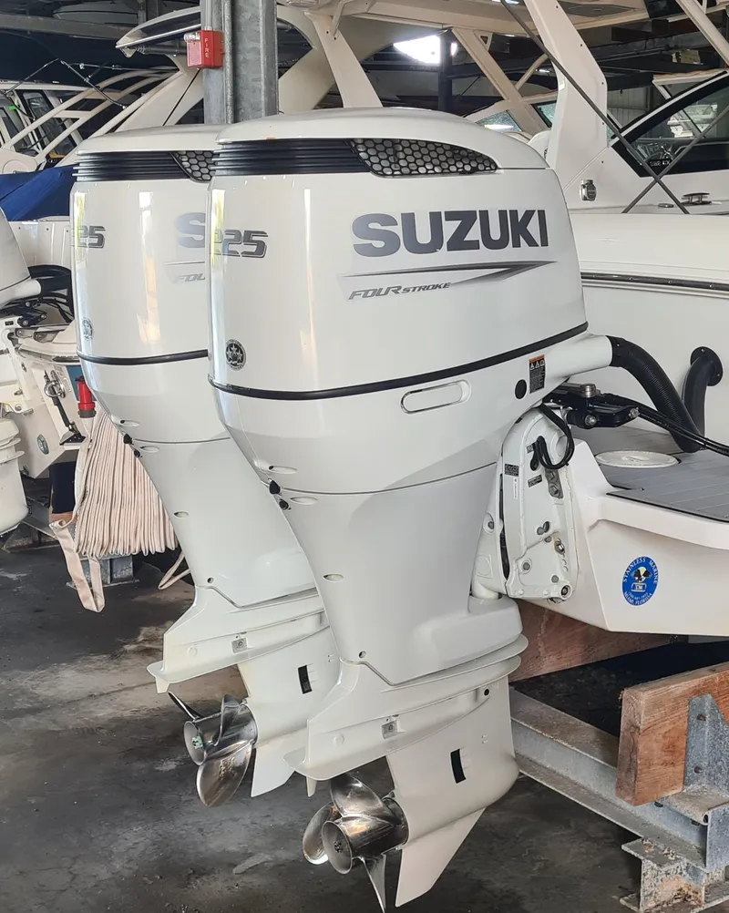 Slide: The Image of 2021 Clearwater 2800 CC with dual Suzuki outboard motors in a marina setting. - 4