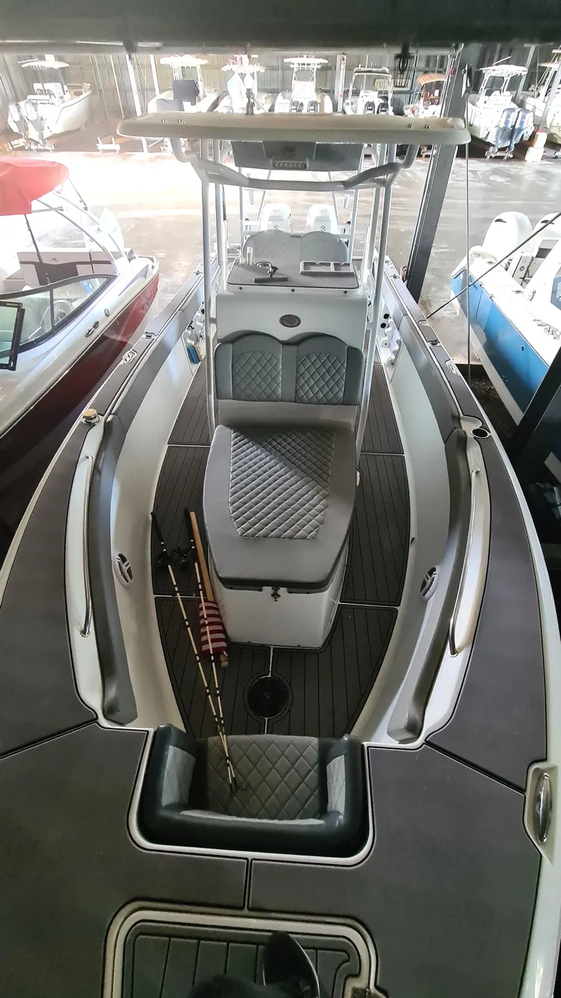 Slide: The Image of 2021 Clearwater 2800 CC boat with center console and cushioned seating in a marina. - 8