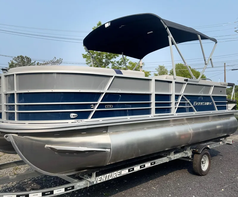 Slide: The Image of 2025 Berkshire 22CL CTS pontoon boat on trailer, featuring a sleek blue and silver design. - 3