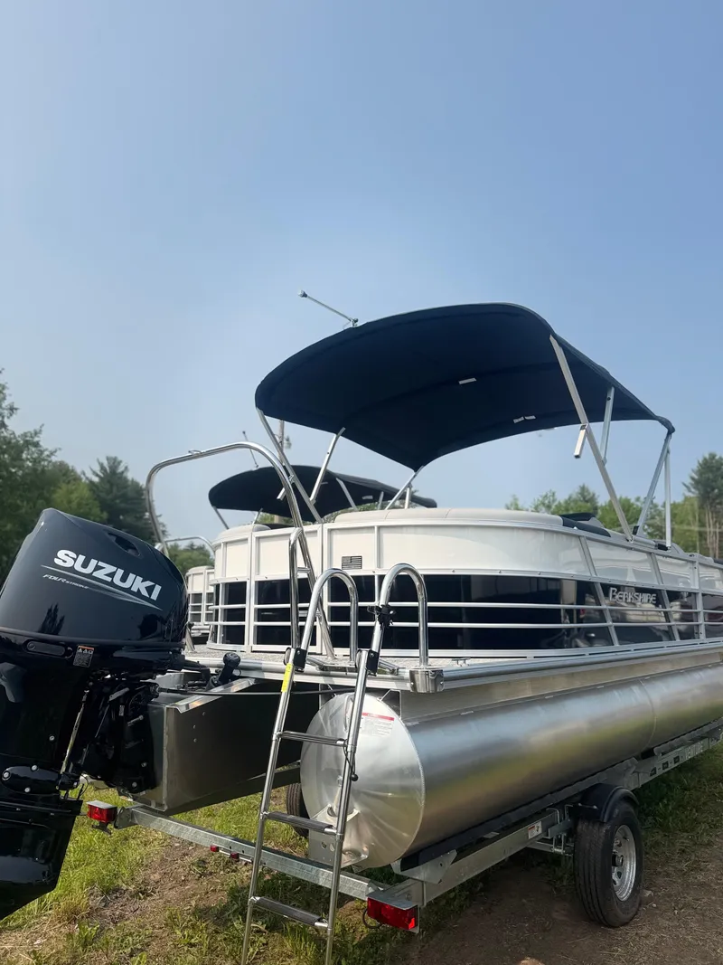 Slide: The Image of 2025 Berkshire 22RFX LE pontoon boat with Suzuki outboard motor, parked on trailer. - 4
