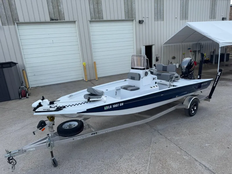 The Image of 2022 Xpress H20B boat on trailer, parked outside industrial building. - 0