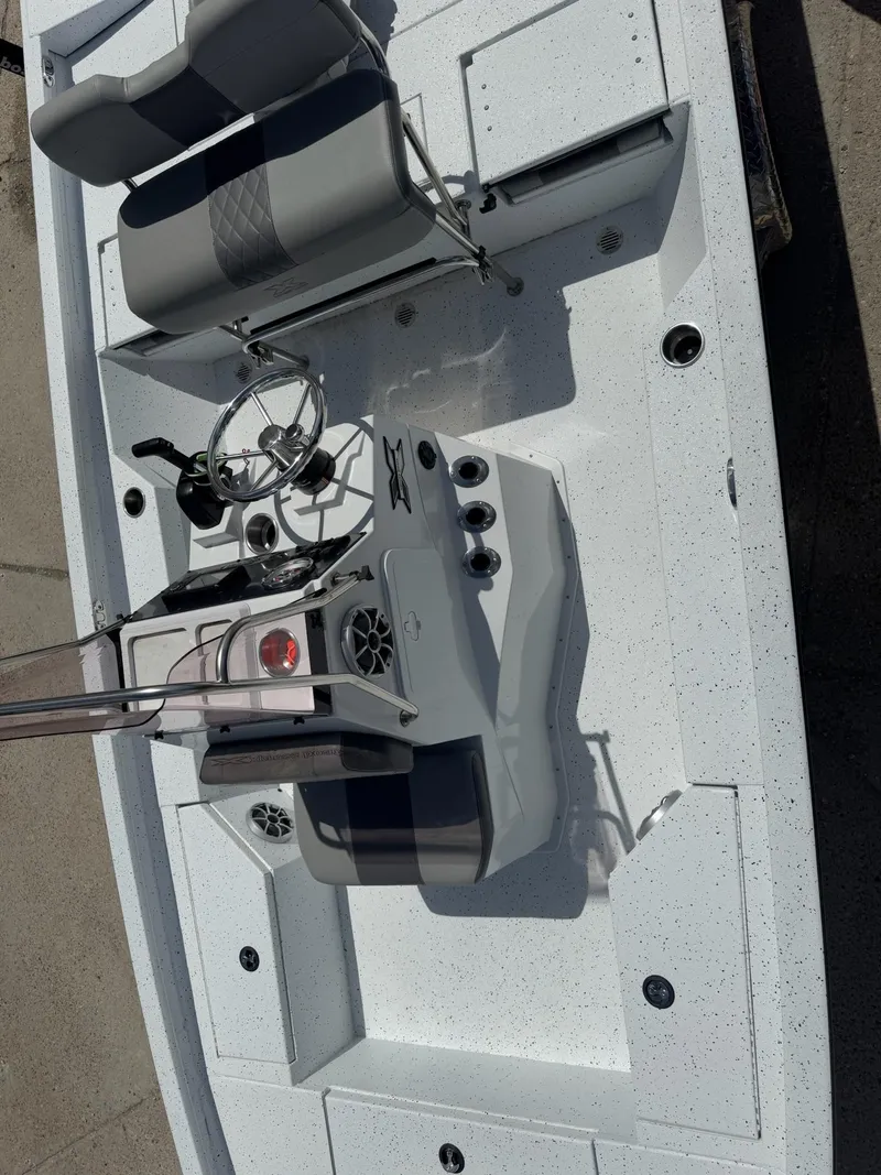 Slide: The Image of 2022 Xpress H20B boat interior with steering console and seating, viewed from above. - 14