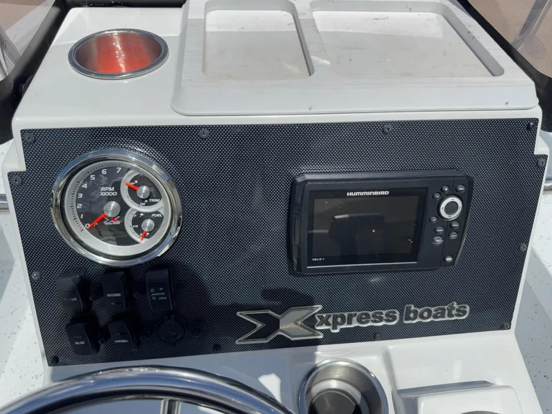 Slide: The Image of 2022 Xpress H20B boat dashboard with gauges and Humminbird Helix 5 display. - 19