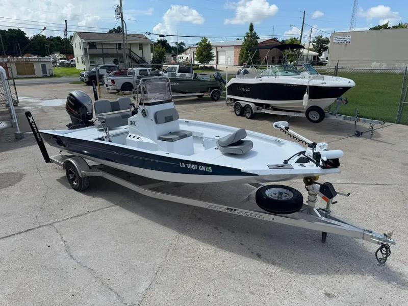Slide: The Image of 2022 Xpress H20B boat on trailer in a parking lot, surrounded by other boats. - 2