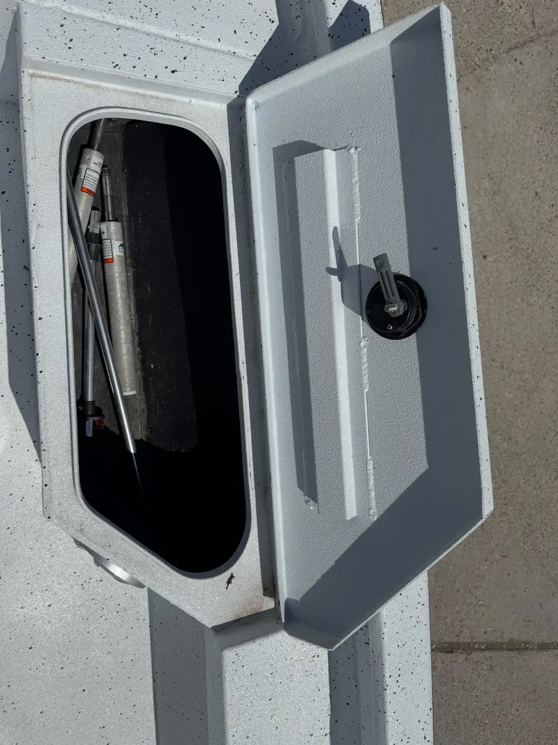 Slide: The Image of Open storage compartment on 2022 Xpress H20B boat, showing interior and hydraulic components. - 26