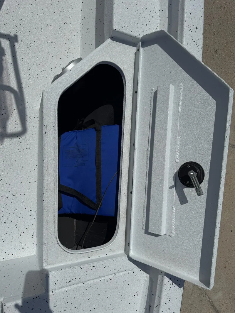 Slide: The Image of Open storage compartment on 2022 Xpress H20B boat with blue bag inside. - 27
