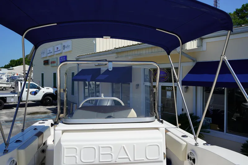 Slide: The Image of 2017 Robalo R200ES boat with blue canopy, docked at a marina. - 22