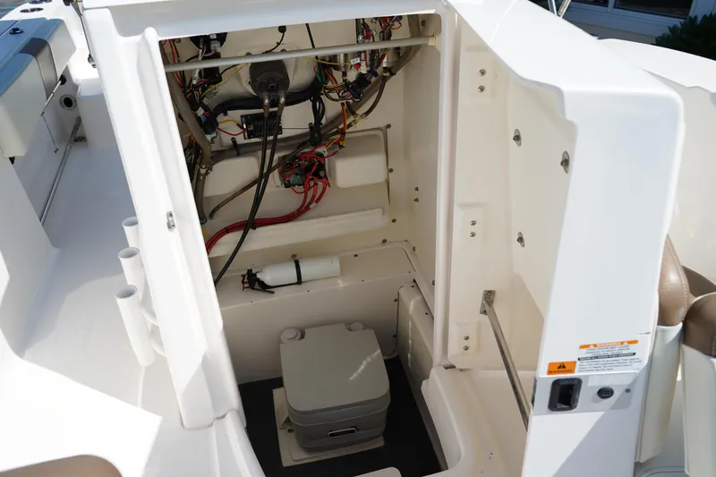 Slide: The Image of 2017 Robalo R200ES boat interior showing wiring and portable toilet. - 23