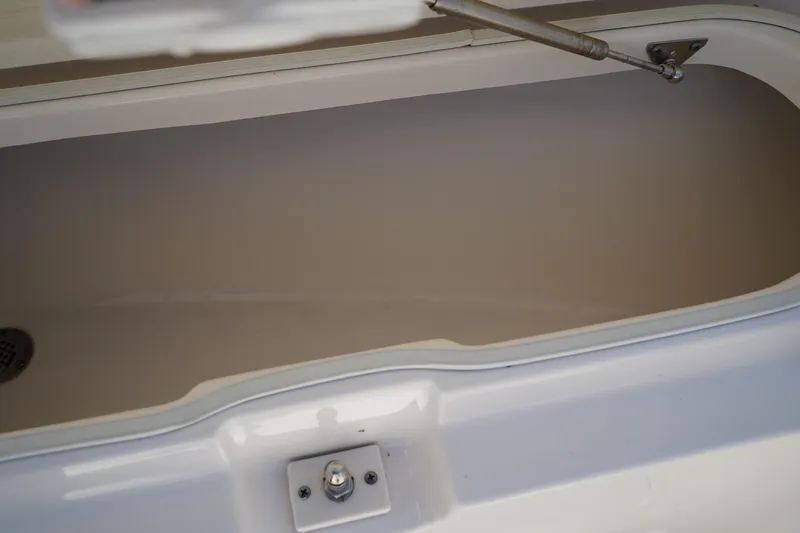 Slide: The Image of Open storage compartment of 2017 Robalo R200ES boat, featuring a clean interior and secure latch. - 27