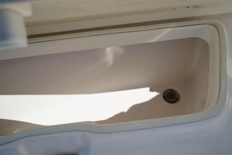 Slide: The Image of 2017 Robalo R200ES boat storage compartment with drain. - 28