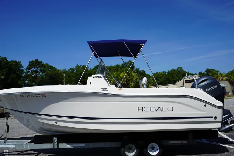Slide: The Image of 2017 Robalo R200ES boat with Yamaha engine on trailer, blue canopy, clear sky background. - 3