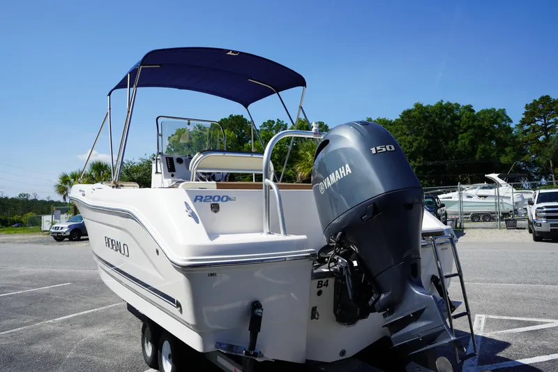 Slide: The Image of 2017 Robalo R200ES boat with Yamaha 150 engine, parked outdoors under clear blue sky. - 5