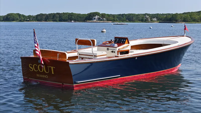 The Image of Classic 1989 Boca Grande 26 boat on calm water, featuring wooden accents and American flag. - 0