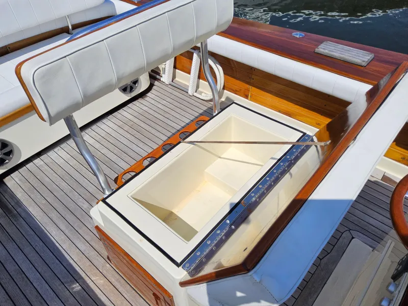 Slide: The Image of 1989 Boca Grande 26 boat interior with open storage compartment and cushioned seating. - 10