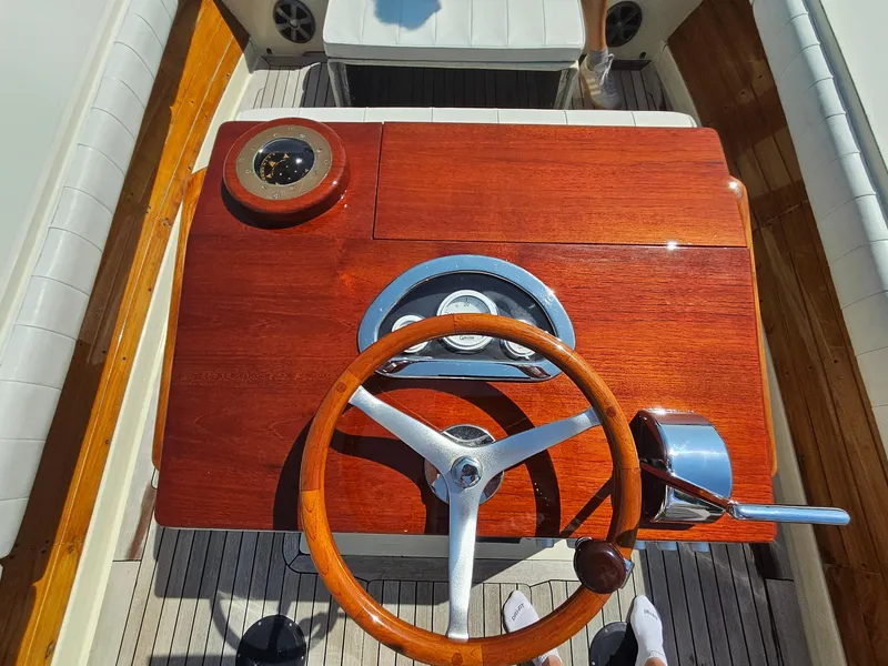 Slide: The Image of 1989 Boca Grande 26 boat helm with wooden steering wheel and classic dashboard. - 13