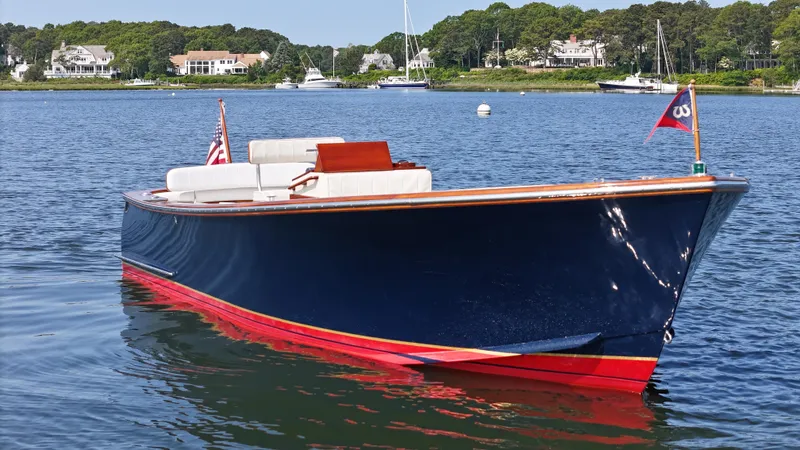 Slide: The Image of 1989 Boca Grande 26 boat with blue hull and red trim on a calm lake. - 2