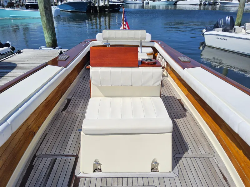 Slide: The Image of 1989 Boca Grande 26 boat interior with white seating, wooden accents, docked at marina. - 24