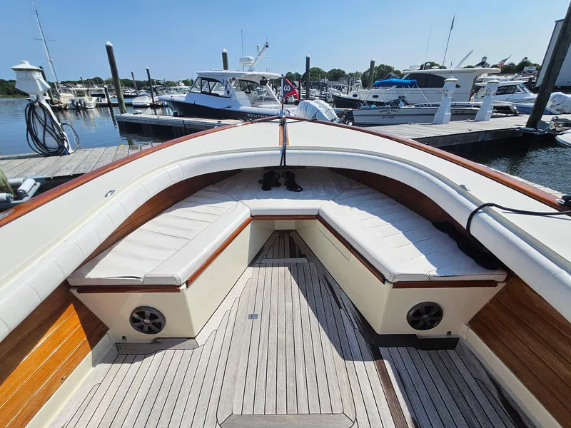 Slide: The Image of 1989 Boca Grande 26 boat with cushioned seating, docked at a marina. - 25