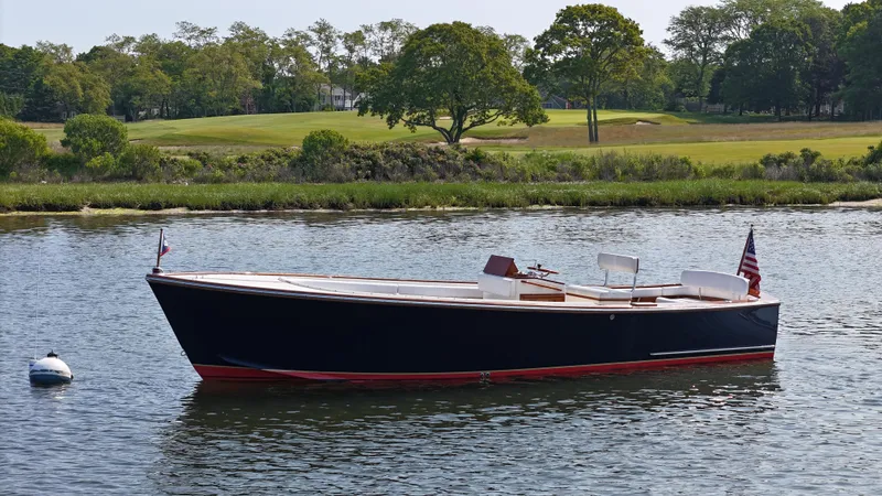 Slide: The Image of 1989 Boca Grande 26 boat on calm water, with lush greenery in the background. - 4