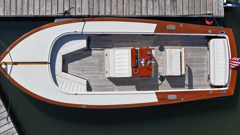 Slide: The Image of Aerial view of 1989 Boca Grande 26 boat docked, featuring wooden deck and white seating. - 5