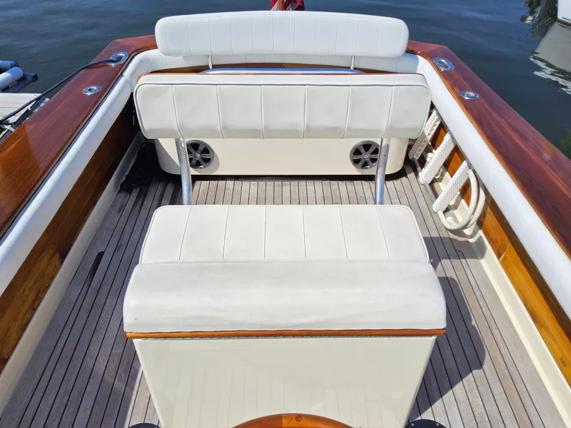Slide: The Image of 1989 Boca Grande 26 boat interior with white cushioned seating and wooden accents. - 9