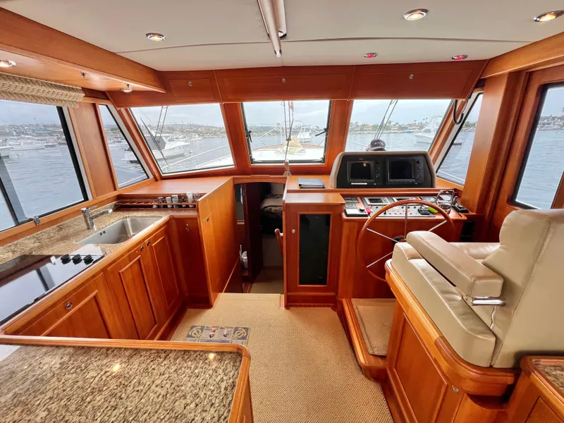 Slide: The Image of 2008 Grand Banks 47 Heritage EU yacht interior with helm, wooden cabinetry, and granite countertops. - 10