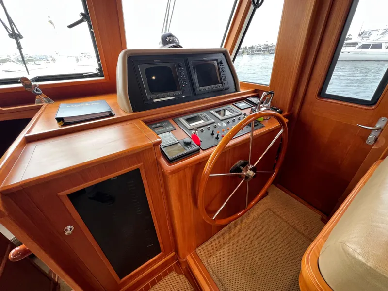 Slide: The Image of 2008 Grand Banks 47 Heritage EU helm with wooden wheel and navigation controls. - 16