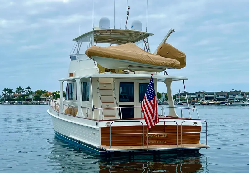 Slide: The Image of 2008 Grand Banks 47 Heritage EU yacht on calm water, displaying an American flag. - 2