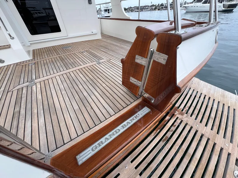 Slide: The Image of Teak deck of 2008 Grand Banks 47 Heritage EU yacht, featuring elegant woodwork and branding. - 45