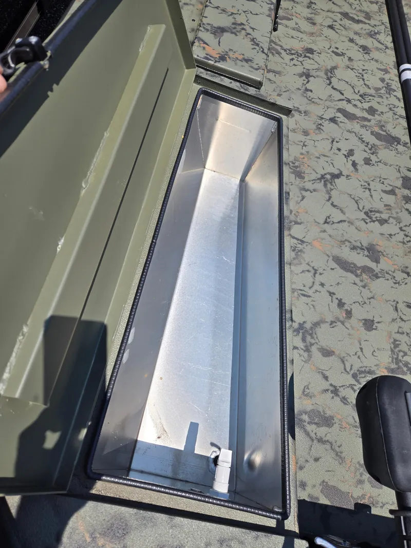 Slide: The Image of 2025 Excel 1754 F4 Shallow Water boat storage compartment, open lid, camouflage interior. - 19