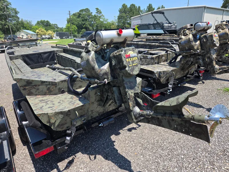 Slide: The Image of 2025 Excel 1754 F4 Shallow Water boat with camouflage design, parked outdoors. - 21