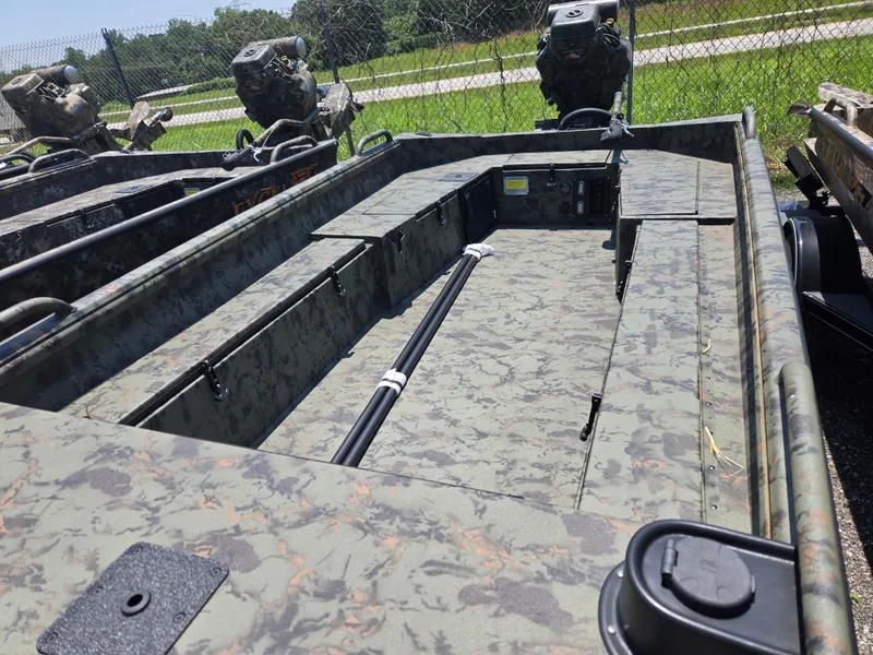 Slide: The Image of 2025 Excel 1754 F4 Shallow Water boat with camouflage design, parked outdoors. - 22