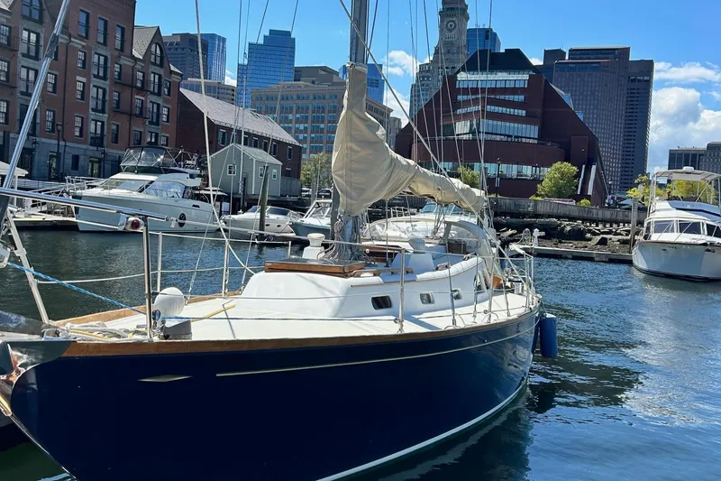 Slide: The Image of Sailboat LeComte Northeast 38, 1967, docked in urban marina with city skyline. - 2