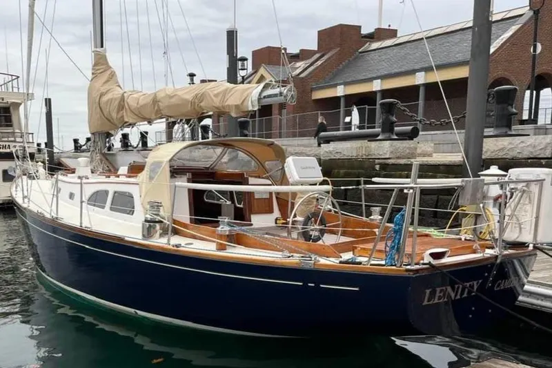 Slide: The Image of 1967 LeComte Northeast 38 sailboat docked at a marina, featuring classic design and wooden accents. - 3