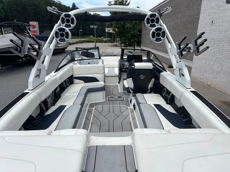 Slide: The Image of 2019 Malibu Wakesetter 24 MXZ interior with white and gray seating, tower speakers, and sleek design. - 6