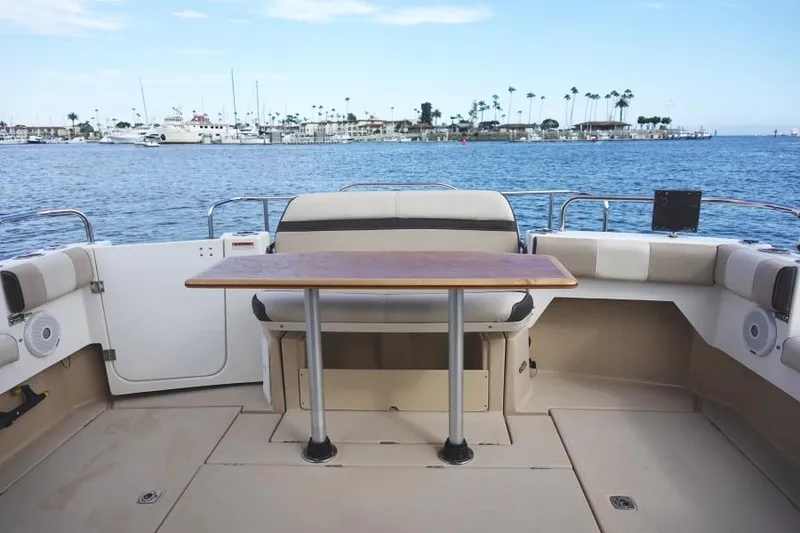 Slide: The Image of 2015 Cutwater 30 Sedan LE boat interior with table, overlooking marina and ocean. - 10