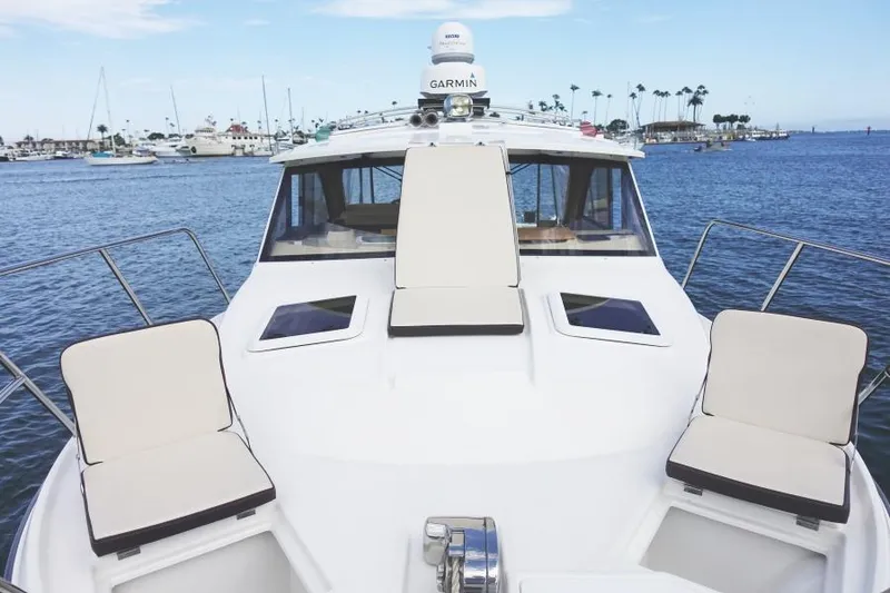 Slide: The Image of 2015 Cutwater 30 Sedan LE boat with cushioned seating, docked in a marina. - 12