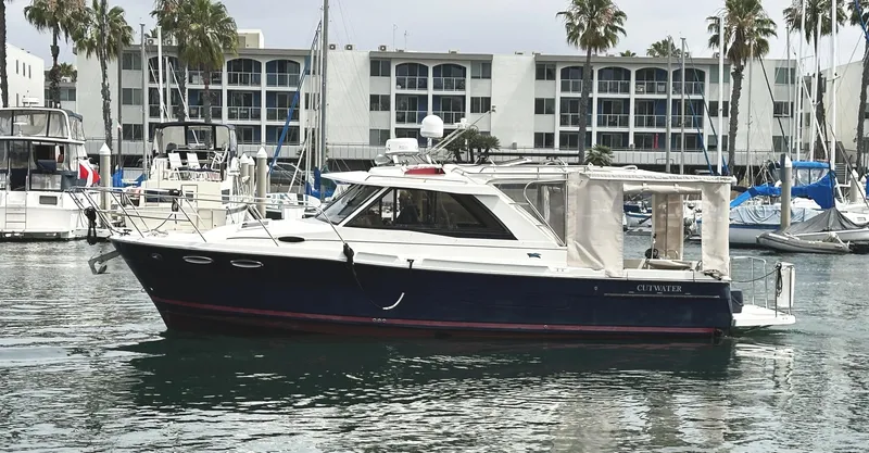 Slide: The Image of 2015 Cutwater 30 Sedan LE boat docked in marina with palm trees and buildings. - 5