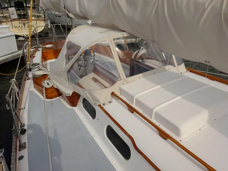 Slide: The Image of 1964 Hinckley Bermuda 40 Custom sailboat with white deck and wooden accents, docked in a marina. - 17