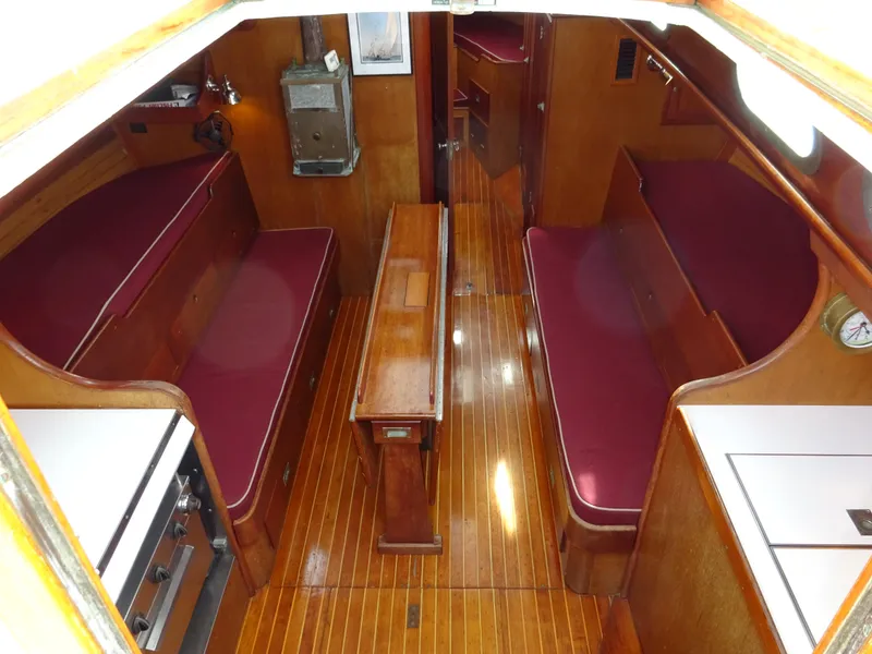 Slide: The Image of Interior of 1964 Hinckley Bermuda 40 Custom sailboat with wooden furnishings and red seating. - 2