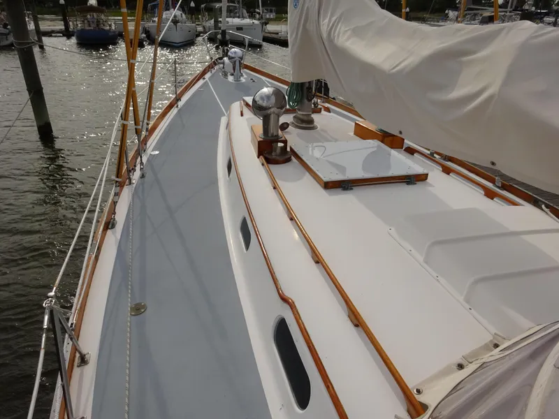 Slide: The Image of 1964 Hinckley Bermuda 40 Custom sailboat deck with wooden trim, docked in a marina. - 22