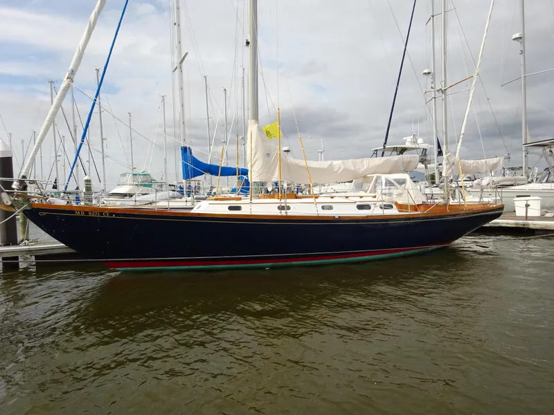 Slide: The Image of 1964 Hinckley Bermuda 40 Custom sailboat docked in a marina, under cloudy skies. - 3