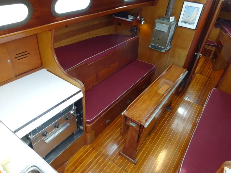 Slide: The Image of Interior of 1964 Hinckley Bermuda 40 Custom sailboat with wood finish and maroon seating. - 30
