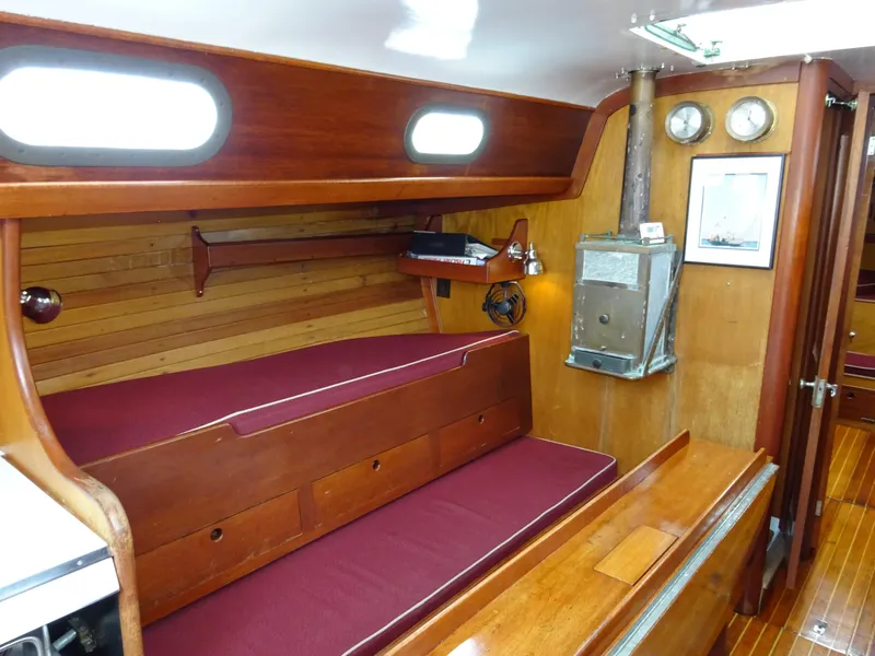Slide: The Image of Interior of 1964 Hinckley Bermuda 40 Custom sailboat with wooden furnishings and maroon cushions. - 32