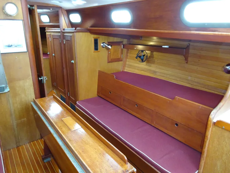 Slide: The Image of Interior of 1964 Hinckley Bermuda 40 Custom sailboat with wooden furnishings and maroon seating. - 33